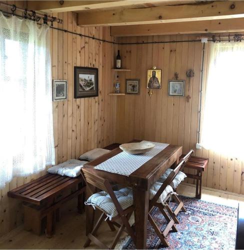 a dining room with a wooden table and chairs at Black Lake House Dajovic in Žabljak
