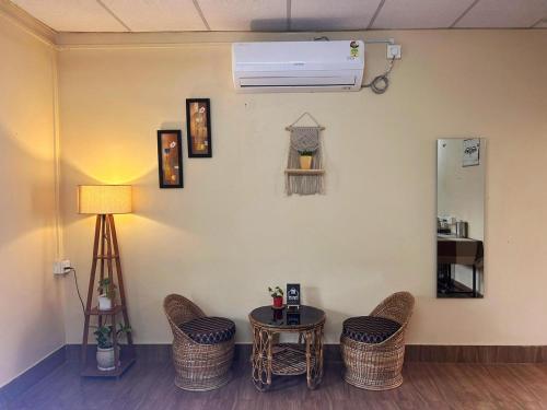 a room with a table and chairs and a fan at Mulaqat Homestay in Siliguri