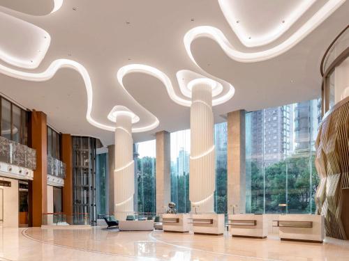 a lobby with large windows in a building at Pullman Shanghai Central in Shanghai