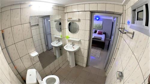 a bathroom with two sinks and two mirrors at The Yafé Bastos 9 in Yaoundé