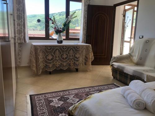 a room with a table with a vase of flowers on it at House of Leaves in Berat