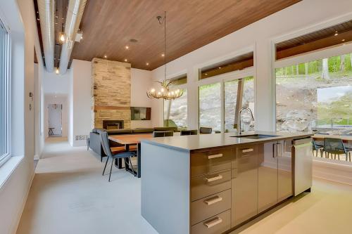 an open kitchen and dining room with a wooden ceiling at Modern Luxury Chalet Private Jacuzzi in La Conception