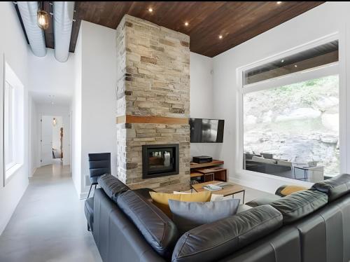a living room with a couch and a fireplace at Modern Luxury Chalet Private Jacuzzi in La Conception