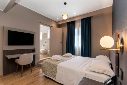 a bedroom with a bed and a desk and a television at Hotel San Remo in Rome