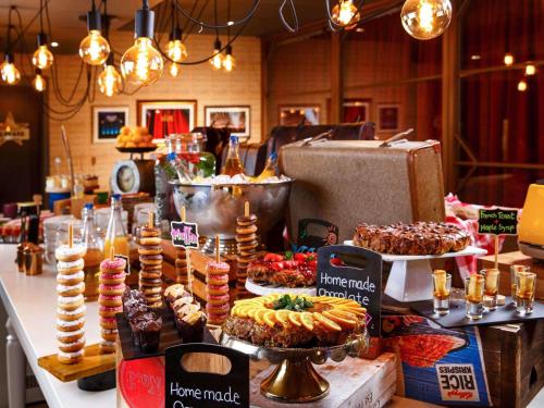 a table with various desserts and pastries on it at ibis Styles London Southwark - near Borough Market in London