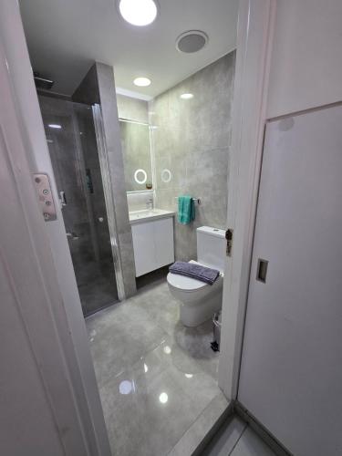 a bathroom with a toilet and a shower and a sink at Yialos Holiday Apartments in Perivolia