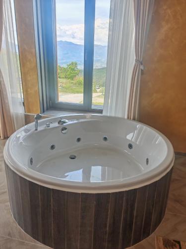 a large wooden tub in a bathroom with a window at Leshtenski Rai Guest House in Leshten