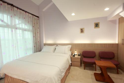 a bedroom with a large bed and two chairs at Gancheng 35 in Jian