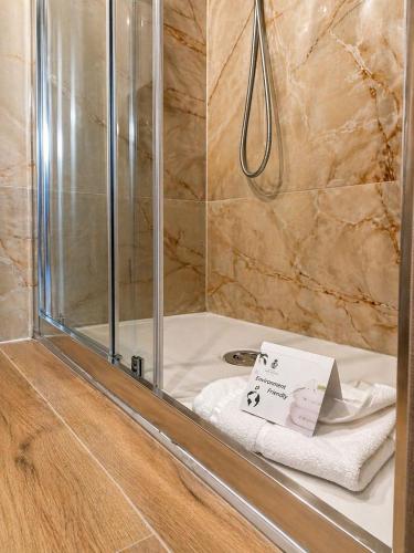 a shower in a bathroom with a towel on a tub at Hotel San Remo in Rome