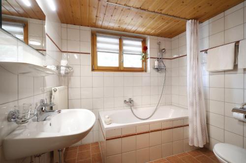 a bathroom with a sink and a bath tub at Aparthotel Bergkristall in Brand
