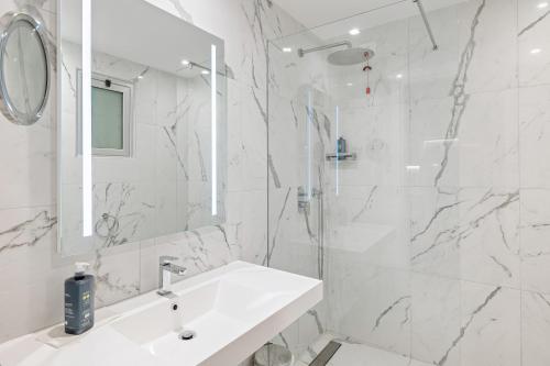 a white bathroom with a sink and a mirror at Aldiana Club Rocca Nettuno Calabria in Tropea