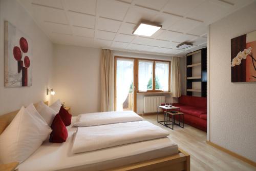 a hotel room with two beds and a red couch at Aparthotel Bergkristall in Brand
