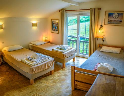 a room with three beds and a window at Amama Baita in Urrugne