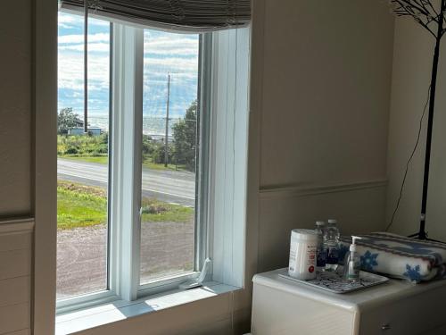 a window in a living room with a table at Couchers de soleil à Sainte-Flavie in Sainte-Flavie