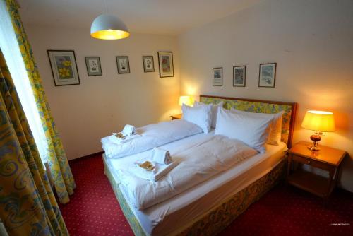 a bedroom with a bed with white sheets and pillows at Chalet Miravalle 1 in Wengen