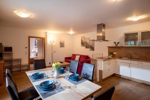 a dining room and kitchen with a table and chairs at Sonnplatzl Appartement Westendorf in Westendorf