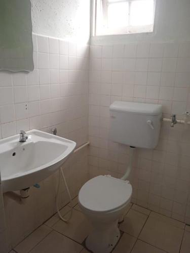 a bathroom with a white toilet and a sink at Cozy Highland in Tanah Rata