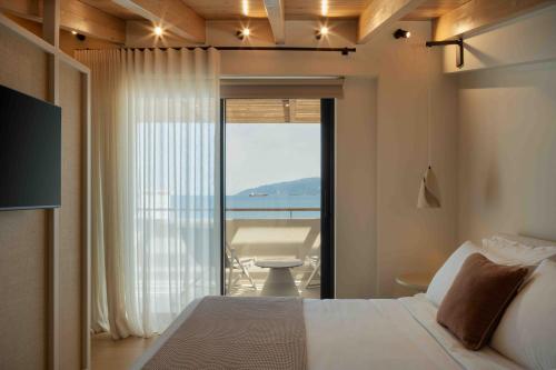 a bedroom with a bed and a view of the ocean at Kelyfos Nafpaktos in Nafpaktos