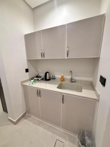 a kitchen with white cabinets and a sink at ايراد للشقق المفروشه in Dammam
