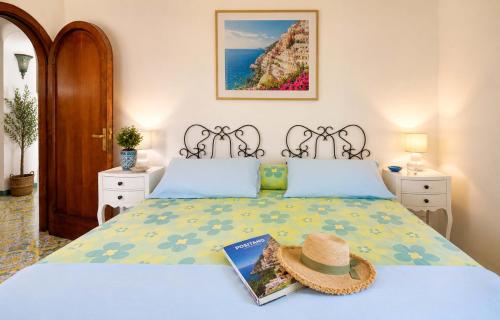 a bedroom with a bed with a hat on it at AMORE RENTALS - Casa Raffi in Positano