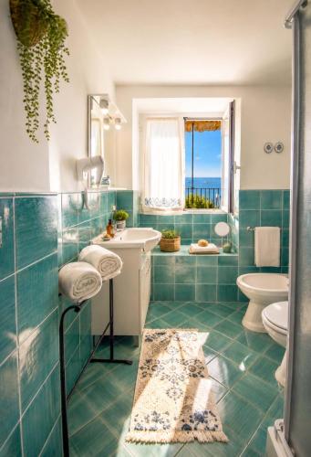a bathroom with a sink and a toilet at AMORE RENTALS - Casa Raffi in Positano