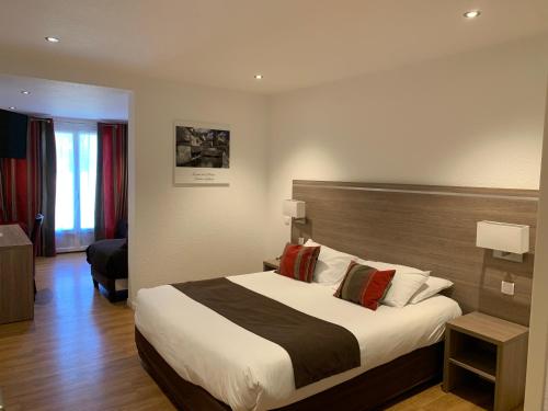 a bedroom with a large bed in a hotel room at Logis Hotel Restaurant de l'Abbaye in Ferrières