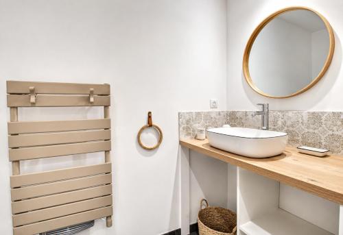 a bathroom with a sink and a mirror at Aux Matins du Bonheur in Surzur