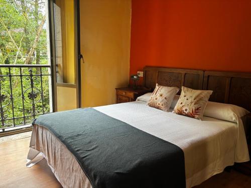 a bedroom with a bed and a large window at Apartamentos Dos Aguas in Aguasmestas