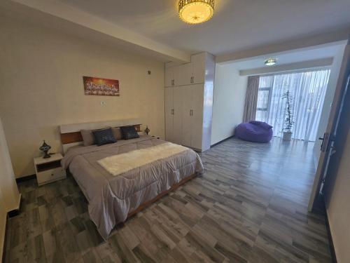 a bedroom with a large bed and a wooden floor at Goldsip lounge in Addis Ababa