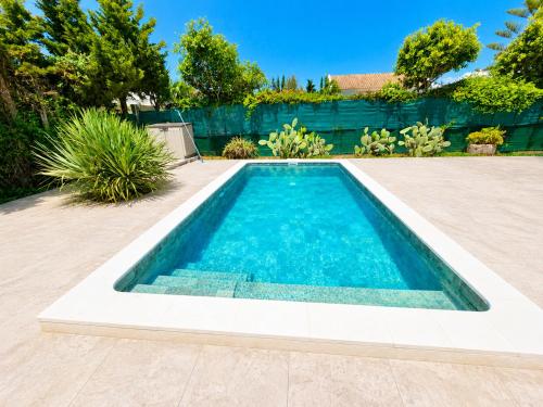 a swimming pool in a backyard with a fence at Casa el Jilguero Conil in Conil de la Frontera
