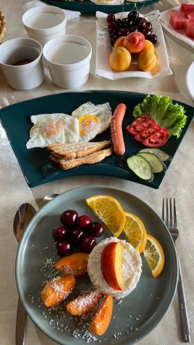 a plate of breakfast food with eggs fruits and vegetables at Muras in Bokonbayevo