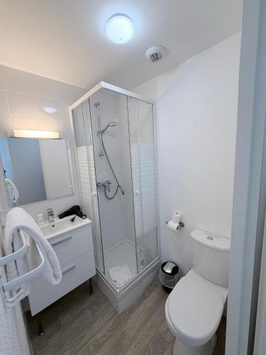 a white bathroom with a shower and a toilet at Cit'Hôtel du Parc in Carrières-sous-Poissy