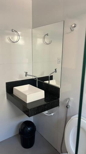 a bathroom with a sink and a mirror at Hotel Rocha in Novo Acordo