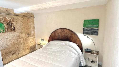 a bedroom with a bed with a wooden headboard at Le Refuge in Denicé