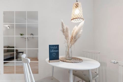 a white dining room table with a book and a chair at Ferienwohnung Tromei-Hof in Oberderdingen