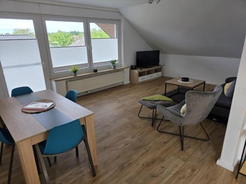 a living room with a table and chairs and a tv at FeWo Weitblick in Sassenburg