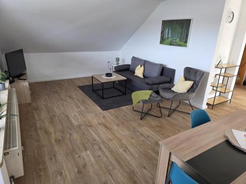 a living room with a couch and chairs at FeWo Weitblick in Sassenburg