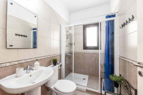 a bathroom with a sink and a toilet and a shower at Villa Sea Side in Polis Chrysochous