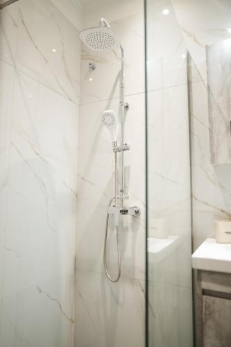 a shower in a bathroom with white marble walls at Meraki luxury bungalows in Rakhónion