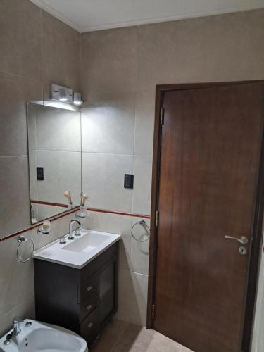 a bathroom with a sink and a toilet and a mirror at Departamento juana con cochera in Rafaela