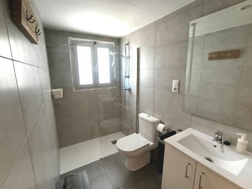 a bathroom with a toilet and a sink and a shower at Seafront Sitges in Sitges