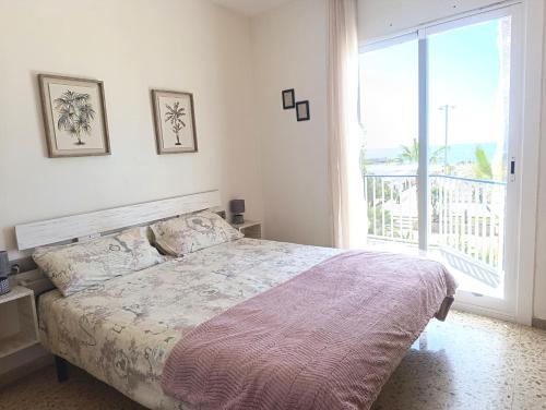 a bedroom with a bed and a large window at Seafront Sitges in Sitges