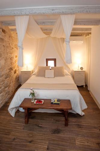a bedroom with a large bed and a wooden table at Antica casa Scesciola in Rutigliano
