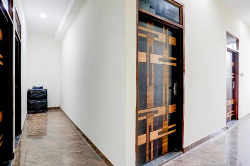 a hallway with wooden doors in a white wall at Hotel O Kalka in Faridabad