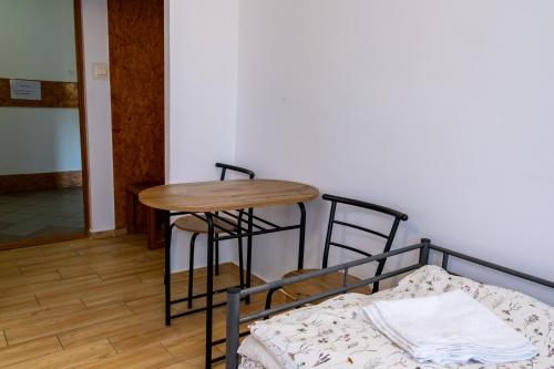a table and stool in a room with a bed at Motel Ketmia in Plecka Dąbrowa