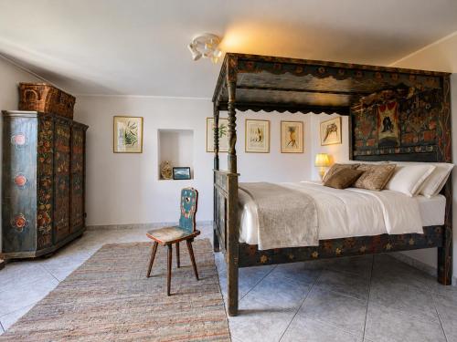a bedroom with a large bed and a chair at Villa Amore in Cannobio
