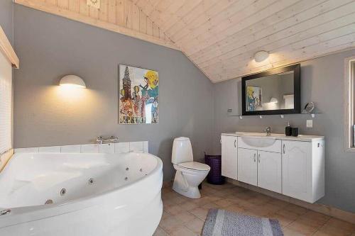 a bathroom with a tub and a toilet and a sink at HA411-Hals-Junovej-13 in Hals