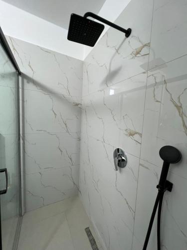 a shower with white marble walls and a shower at Lake Apartment in Sauk