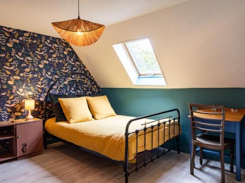a bedroom with a bed and a desk and a window at Gîte De L'alliance in Lannion