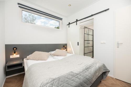 a bedroom with a bed and a window at Vakantiepark Buitenplaats Holten in Rijssen